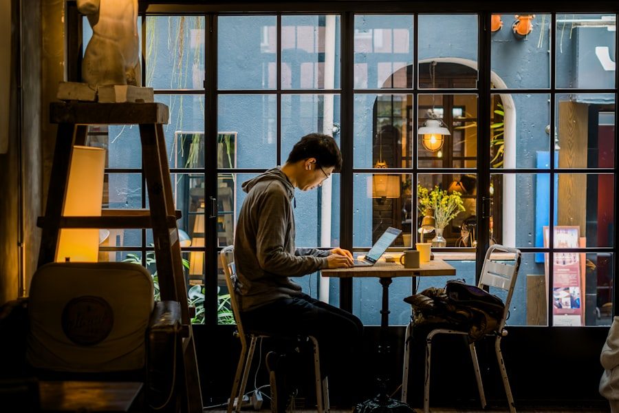 Mann schreibt Webseiteninhalte an seinem Laptop in einem Café